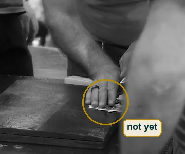 Close crop of the dealer's ringed hand pressing on the small stack of cards
