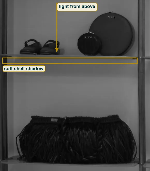 Crop of the left shelves with an arrow for light from above and the soft shadow under a shelf boxed