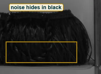 Full-size crop of the fringed black bag and the grey wall, the dark fringe boxed