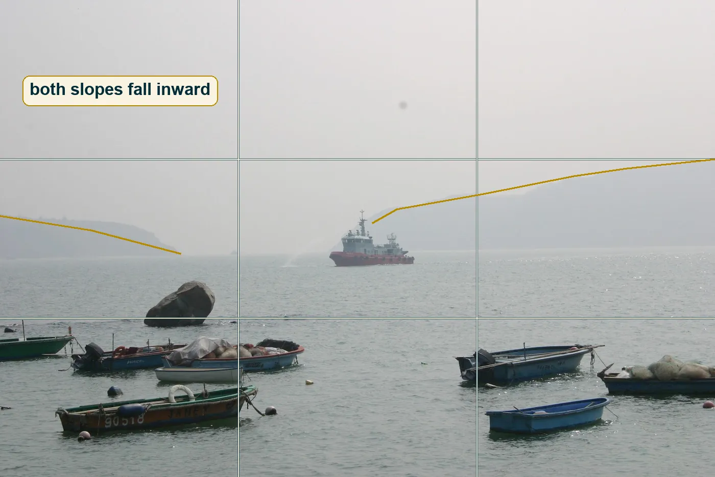 Full photo with a thirds grid and two lines along the hill slopes meeting near the ship