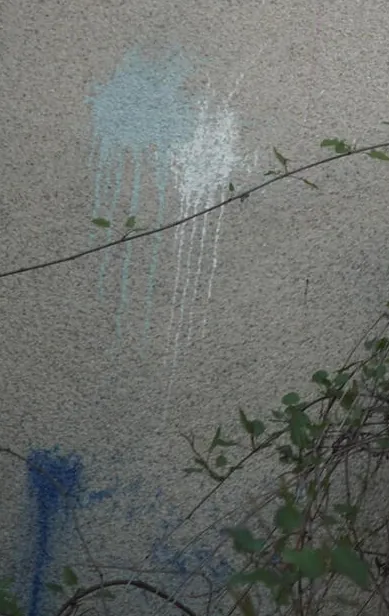 Crop of the lower left wall with pale blue and cobalt paint blots and drips, no bird