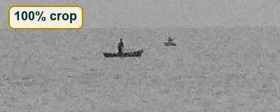 Full-size crop of calm water with a tiny canoe, showing fine grain
