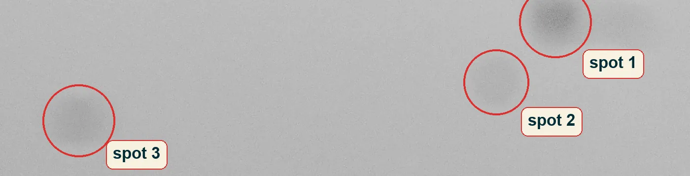 Crop of the upper sky with three soft dark spots circled